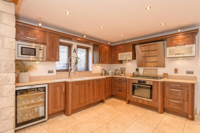 Wall and base units with granite work surfaces and integrated appliances feature within the high spec kitchen.