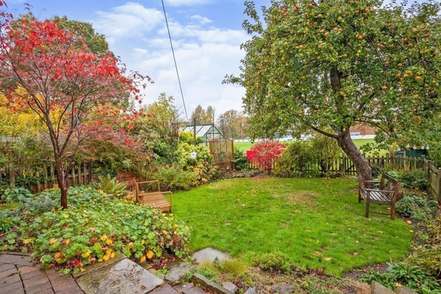 The delightful rear lawned garden is enclosed with mature trees and shrubs.