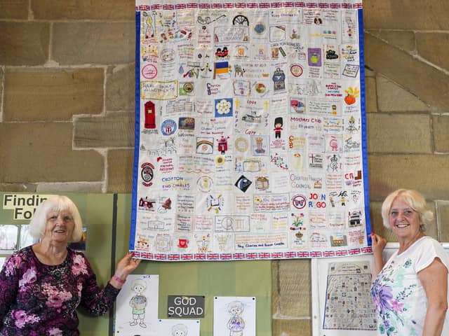 Joan Marsh and Lesley Sellens unveil  a new King Charles III coronation wall hanging at All Saints Church in Crofton.