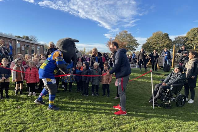 The Leeds Rhinos mascot joins former players Kevin Sinfield and Rob Burrow at the finishing line of the charity walk by youngsters and staff from Orchard Head Junior, Infant and Nursery School, Pontefract.