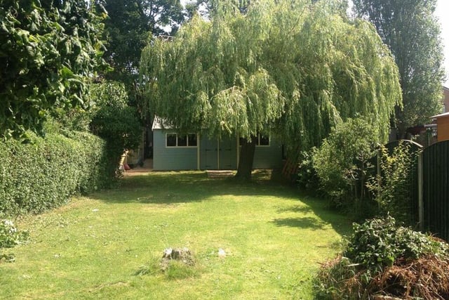The rear lawned and enclosed garden has established trees, plants and shrubs.