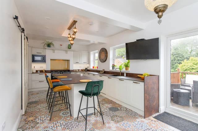 A central island unit with breakfast bar is a feature of the spacious kitchen.