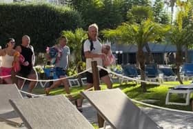 Video filmed at the Melia Hotel, in Benidorm, Spain, shows tourists - armed with their beach towels - hastily making their way to the poolside furniture. (SWNS)