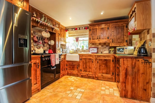The country kitchen has a fitted range of bespoke wooden units and worktops.