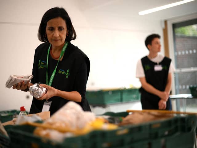 A member of staff sorts through food items inside a food bank in the UK. (Photo by DANIEL Leal/AFP via Getty Images)