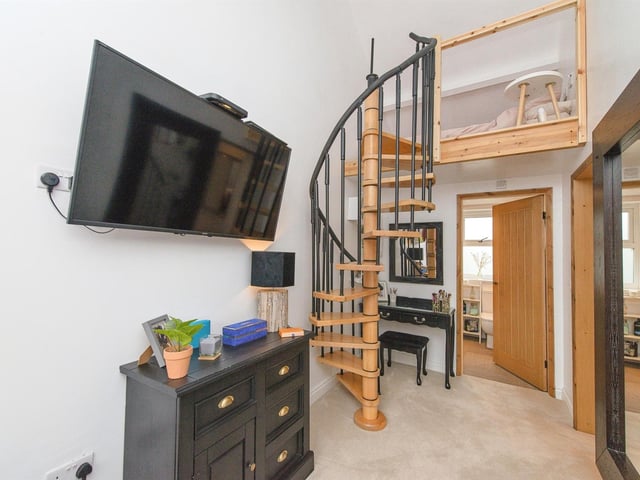 Spiral staircases, one leading to a mezzanine level, add interest to the interior.
