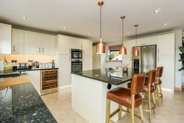 To the kitchen area there is a bespoke range of fitted units with solid granite worktops and a matching island unit.