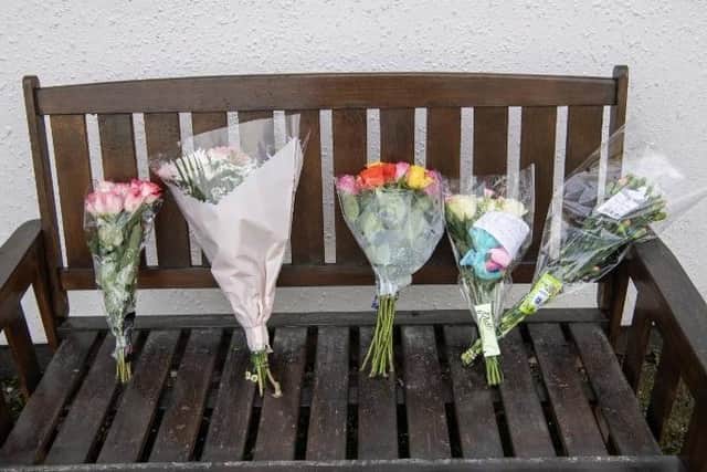 Flowers have been left on the bench outside the pub.