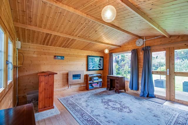 Inside the versatile summerhouse, that has power, light, and a wall-mounted heater.