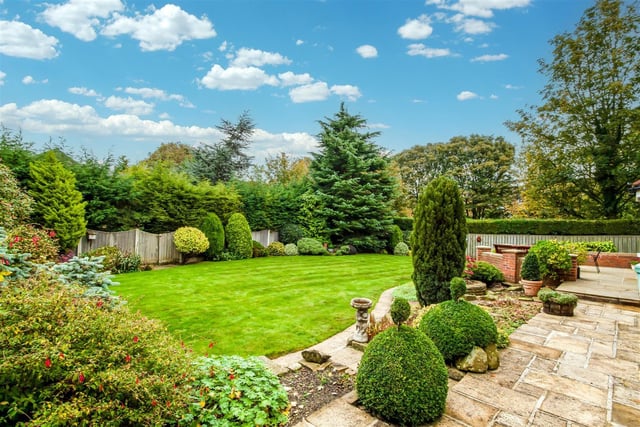The lawned rear garden with patio seating area has established leafy borders and a high degree of privacy.