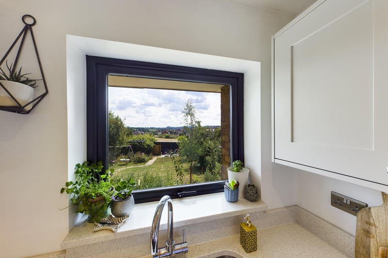 Room with a view: this kitchen window looks over the garden to the landscape stretching out behind.