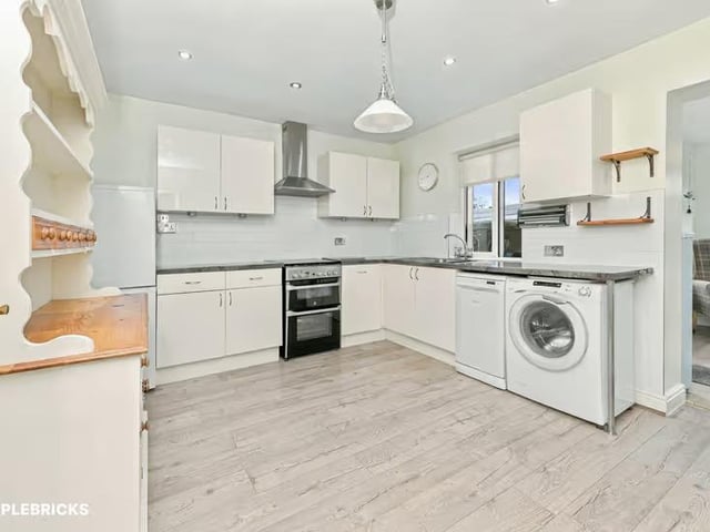 The fitted kitchen provides practical storage and preparation space.