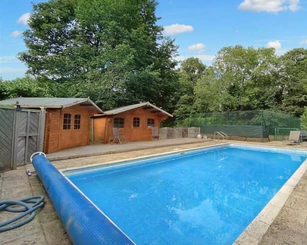 Perfect for warm summers - the property's outdoor pool with tennis court to the rear.