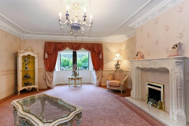 The living room has a Louis XV feature fireplace and looks over the pool, with a bay window.