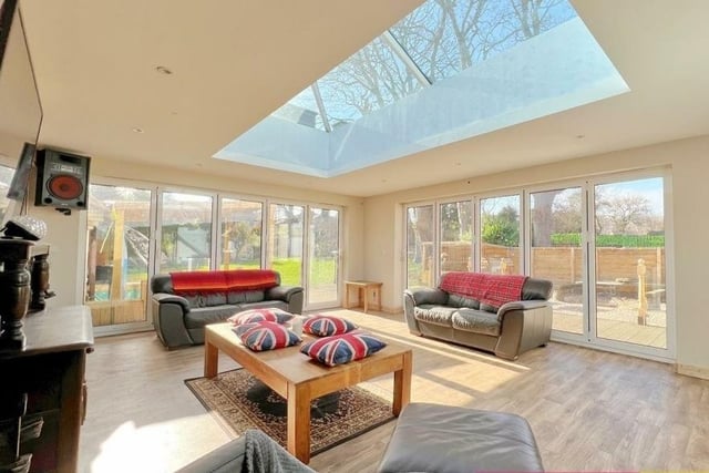 A lantern roof lights up this entertainment room, with bi-folding doors to two sides also creating an indoor to outdoor setting.