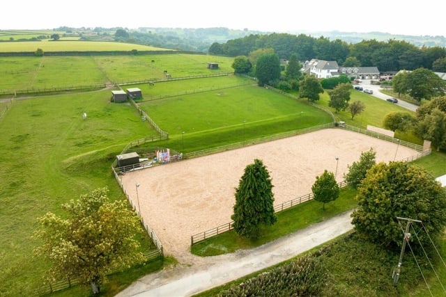 The property includes far-reaching grounds with woodlands and a large commercial stables operation, among other outbuildings. There are 22 stables in total and dull facilities including a washroom, a tack room, a feed room, and an office from which to direct operations. The property also benefits from a large barn, a second smaller hay barn and several stores as well as large fields and fenced paddocks, including an all-weather paddock.