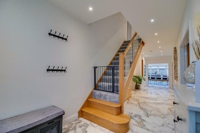 This lovely entrance hall comprimises of a modern composite front entrance door with two side screens, an oak staircase to the first floor, a wall mounted access point for the Anker HomeKit smart home integration and an integrated aquarium through to the kitchen.