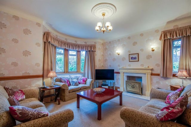 The sitting room features a double central heating radiator, a further feature fireplace with a marble insert and hearth housing a dog grate with a living flame coal effect gas fire.