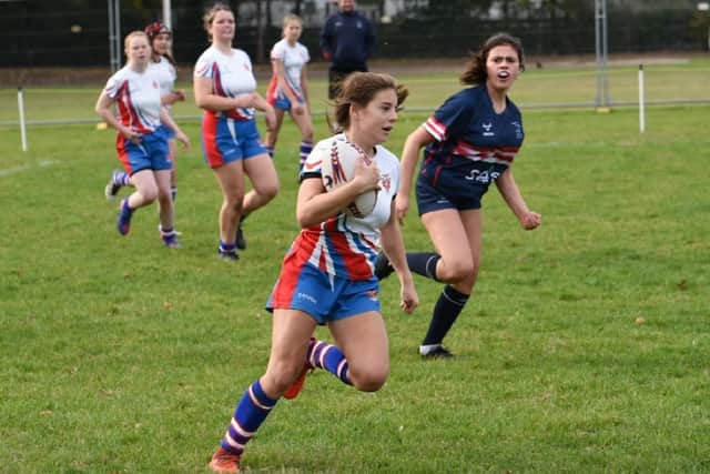 Castleford RUFC Girls U14s player Kate Rawlinson breaks through the Doncaster defence.