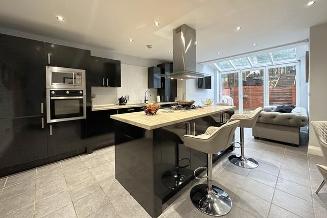 The stunning open plan kitchen with island unit and breakfast bar.