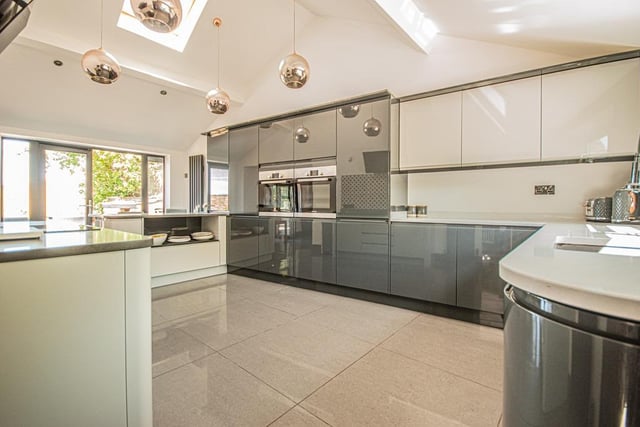 The well-lit kitchen is equipped with high spec units and appliances