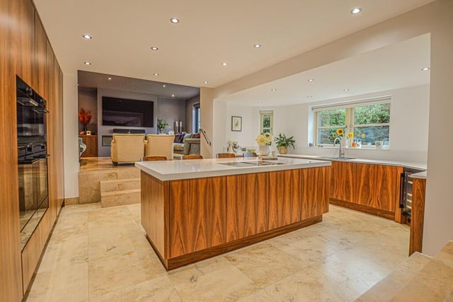 The bespoke fitted kitchen features Walnut storage units and a range of integral appliances including four wifi controlled ovens.