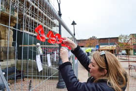 Founder of Ossett Through the Ages, Anne-Marie Fawcett, placing a poppy at the town hall.