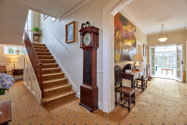 The inviting hallway, with staircase leading up, and conservatory to the rear.