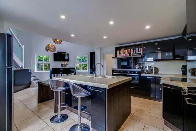 A spacious fitted kitchen with island and breakfast bar.