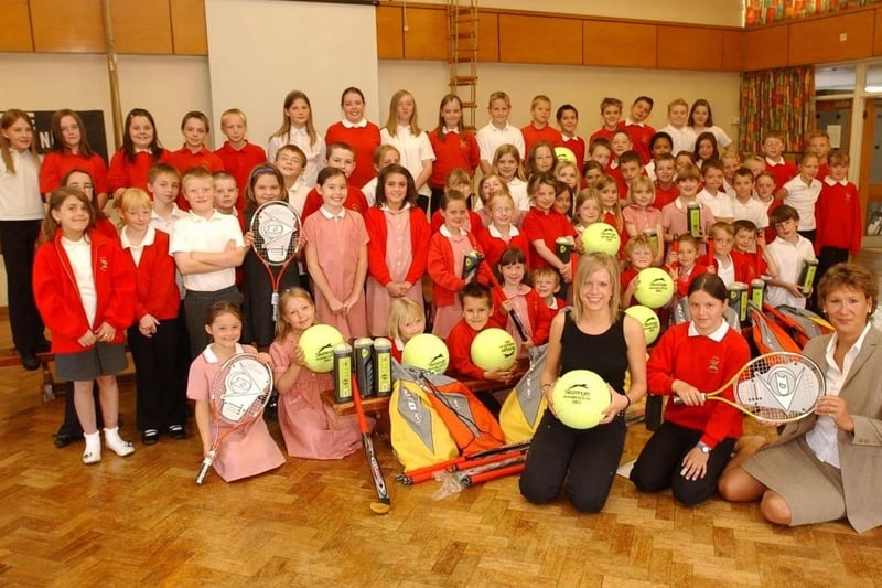 Wrenthorpe Primary School won sports equipment. Helen Knowles of Wakefield hospice hands items to pupil Molly Timms who raise the most money and, teacher Sally Porter in 2004.
