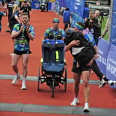 Rob Burrow gets a kiss from his friend Kevin Sinfield as he carries him across the finish line