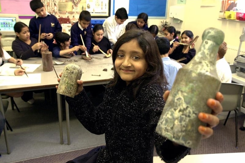 Victorian archaeological finds at Pinders Primary. Shazia Saddique, 10 yrs old, is pictured with two of the Victorian glass bottles that were found during building work at the rear of the school. Others finds included broken pottery and animal bones.
