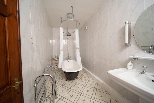 The main bathroom features a free-standing roll top bath with shower over.