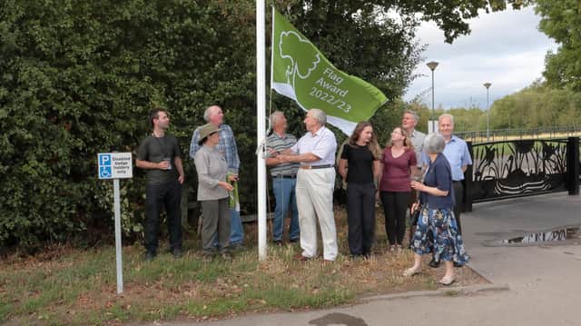 Ricky Donner, chair of Friends of Haw Park Wood & Wintersett volunteer group raises the newly acquired 2022/3 Green Flag.