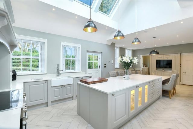 This open plan kitchen/dining area is superbly appointed with a matching range of grey shaker style kitchen units with feature display units, marble worktops and a centre island.