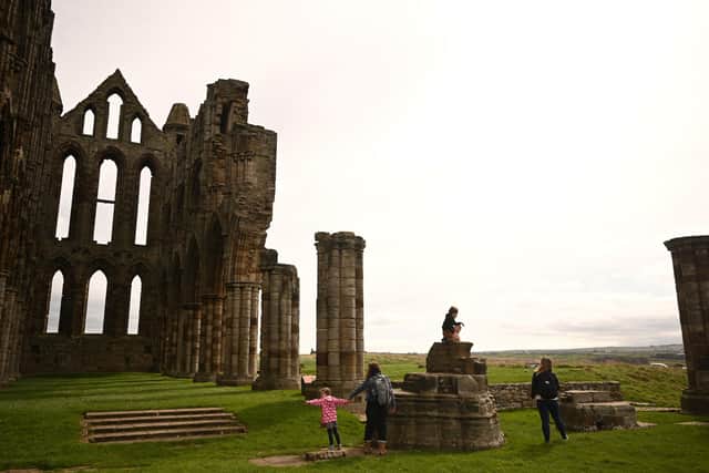 Visitors explore the ruins of English Heritage site, Whitby Abbey. Photo by OLI SCARFF/AFP via Getty Images