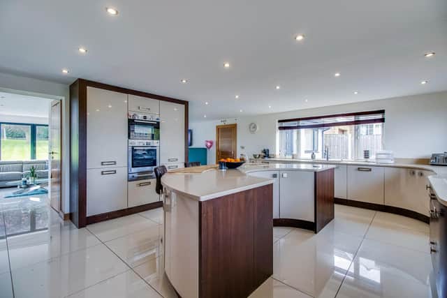The contemporary style kitchen with underfloor heating, granite worktops and integrated appliances, has a central island with breakfast bar.