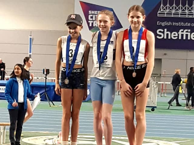 Sienna Lavine (centre) with her gold medal won in the Northern Indoor Championships.