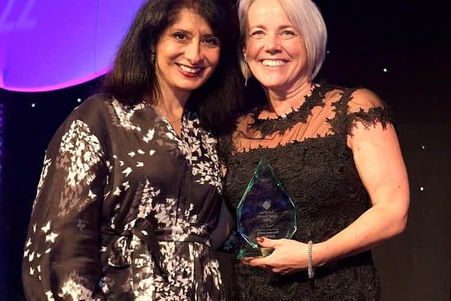 Clare Thornton collecting the award for Best Small Law Firm of the Year 2022 from comedian and host Shappi Khorsandi.