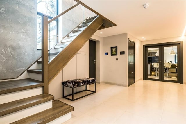 Upon entering the property through the main door there is ample shoe and coat storage, an alarm keypad, a crestron control panel, porcelanosa tiled hallway with a staircase rising to the first floor.