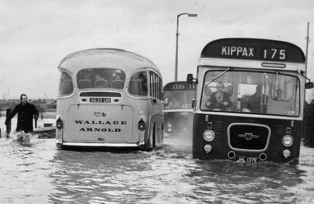Chris Leak splashes along the flooded Castleford-Hook Moor Road at Allerton Bywater in an attempt to keep the traffic moving, 1967.