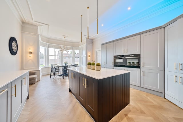 A modern, high spec and open plan kitchen has a large central island.