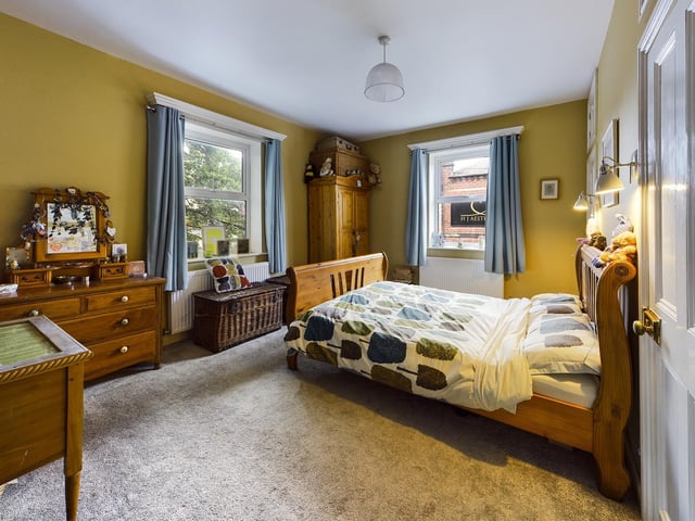 Two large windows bring plenty of natural light in to this bedroom.