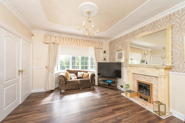 This sitting room has a feature fire surround with period decoration, a bay window and double doors to the hall.