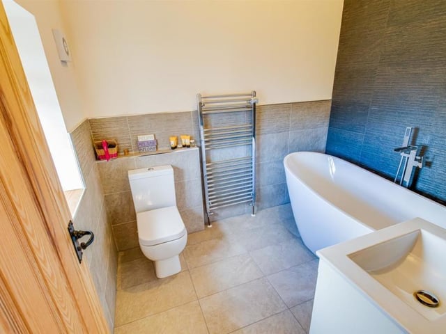 A bathroom with free standing bath and wash basin vanity unit.