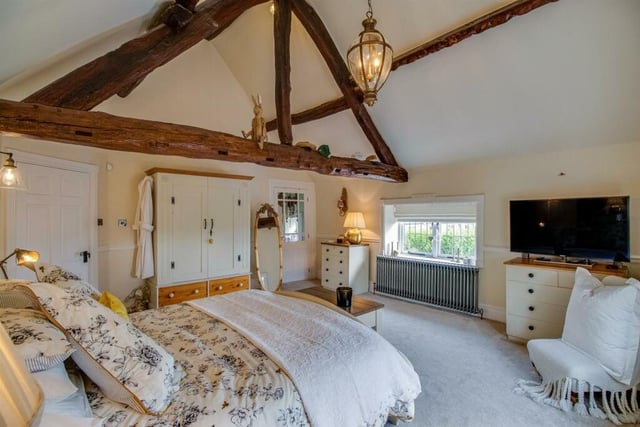 This bedroom includes windows to two sides, heavy wooden beamed ceiling, dado rail and old school style radiator and an additional useful walk in wardrobe with a window overlooking the garden.