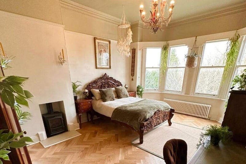 One of the spacious bedrooms, with a bay window and fireplace feature.