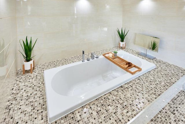 A sunken bath in the main bedroom's stunning en suite facility offers a relaxing end to the day.