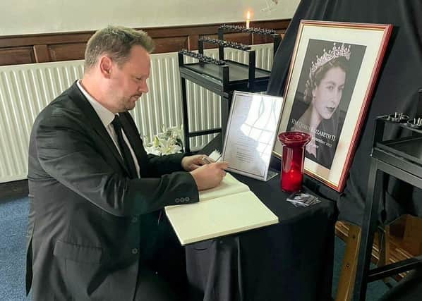 Simon Lightwood MP adding a message to a book of condolence for Queen Elizabeth II.