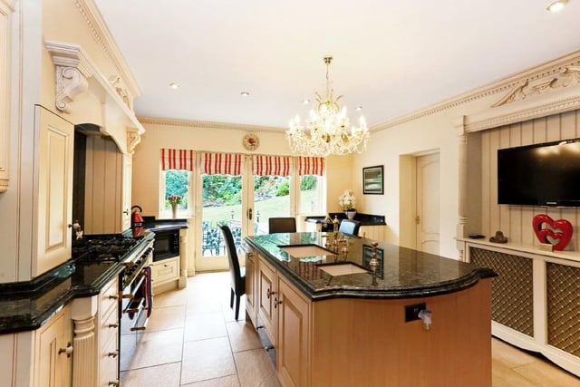 The kitchen has bespoke fitted units with granite work surfaces, and a central island.